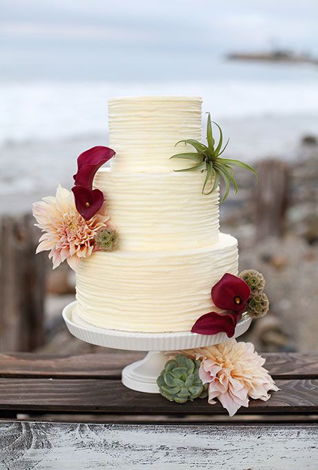 Wedding Cake decorated with burgundy calla lilies, blush dahlias, and air plants, created by The Butter End Cakery. Found on brides.com